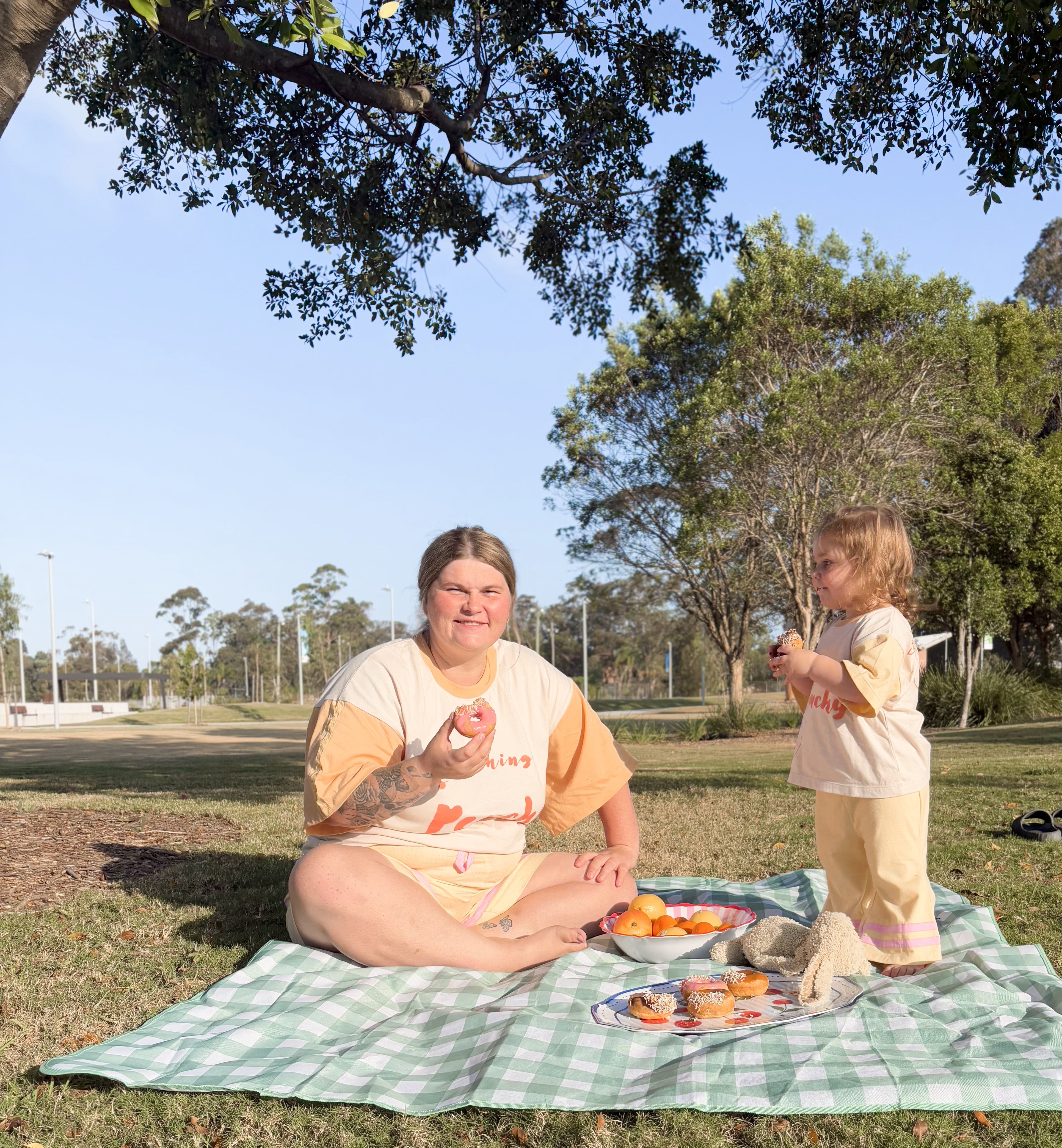 Woman and child sitting on a picnic blanket in a park