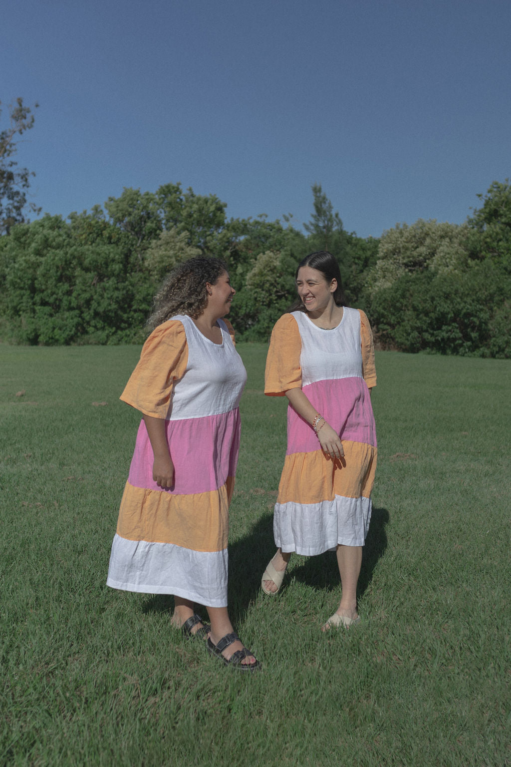 ROSE + REGGIE models wear two linen dresses. Both orange and pink maxi dresses. Slow fashion outfits. 